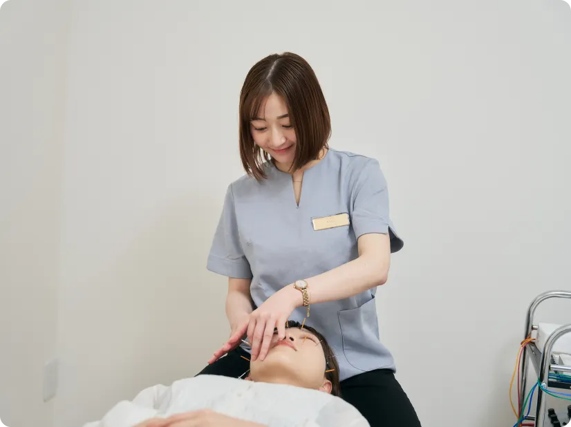 美容鍼の施術で顔に鍼をうつスタッフ